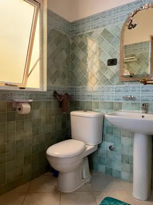 a bathroom with a toilet and a sink at Rosa dei venti 4 in Santa Maria