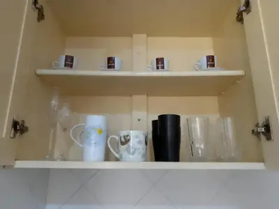 a shelf with cups and mugs on it at Ca' Dolce Vita in Santa Maria