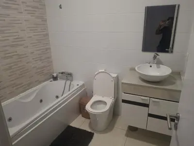 a white bathroom with a toilet and a sink at Apartamento T3 palmarejo center in Praia