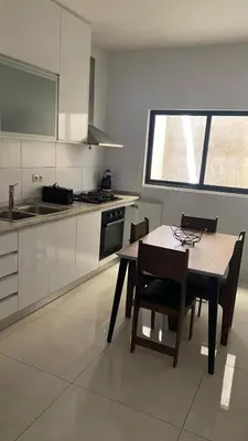 a kitchen with a table and chairs and a window at Apartamento T3 palmarejo center in Praia
