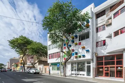 a building with a tree on the side of the street at Modern Flat in Mindelo - 3B in Mindelo