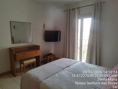 a bedroom with a bed and a dresser and a mirror at Mb HOUSE VILA VERDE RESORT in Prainha