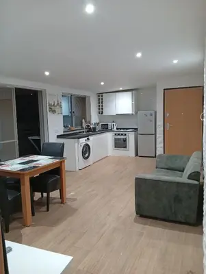 a kitchen and living room with a table and a couch at Praia Sunset Horizon Apartment