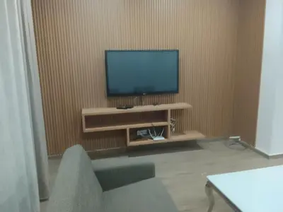 a living room with a television on a wall at Praia Sunset Horizon Apartment