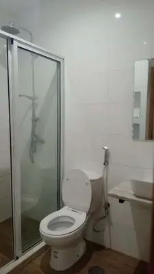 a white bathroom with a toilet and a shower at Praia Sunset Horizon Apartment
