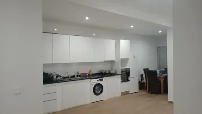 a kitchen with white cabinets and a stove top oven at Praia Sunset Horizon Apartment