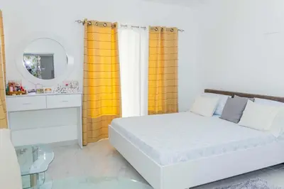 a bedroom with a white bed and a mirror at Hospedaria Santo António in Praia Baixo