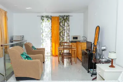 a living room with two chairs and a television at Hospedaria Santo António in Praia Baixo