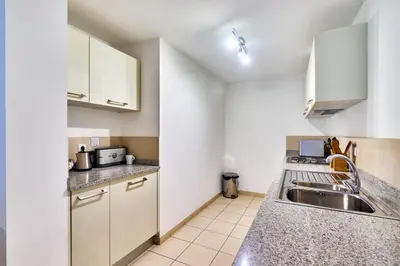 a kitchen with white cabinets and a sink at T2 Santa Maria, Ilha do Sal, Cabo Verde - Melia Tortuga Beach Resort in Prainha