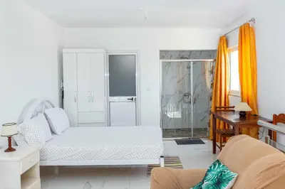 a white living room with a bed and a desk at Hospedaria Santo António