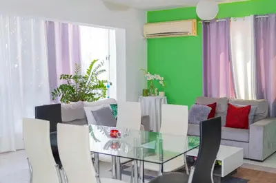 a dining room with a glass table and white chairs at Hospedaria Santo António