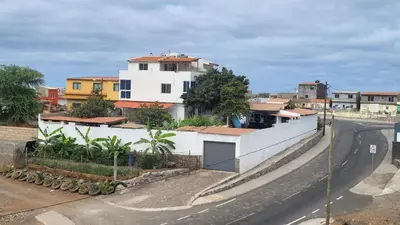 a white building on the side of a road at Hospedaria Santo António