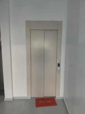 a white elevator with a red door in a building at C&C Guesthouse in Praia
