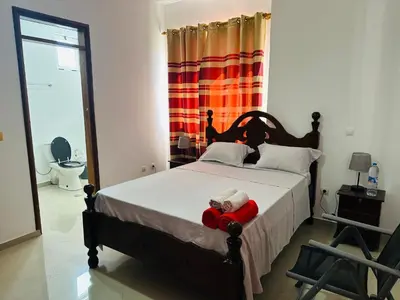 a bedroom with a bed with a teddy bear on it at Villa Esperança in Tarrafal