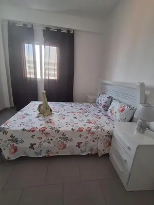 a bedroom with a bed with a flowery comforter at Apartamento Estoril in Sal Rei