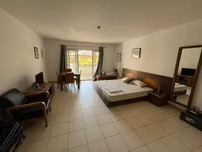 a bedroom with a bed and a chair and a mirror at Vila Verde cozy studio in Prainha