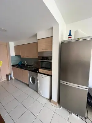 a kitchen with a stainless steel refrigerator and a dishwasher at Vila Verde cozy studio in Prainha
