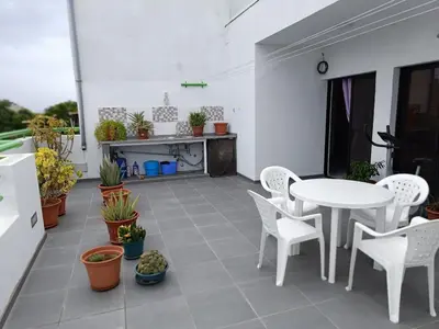 a patio with a white table and chairs and plants at Apartament in Praia in Praia
