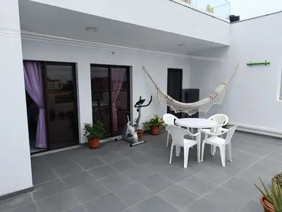a patio with a hammock and a table and chairs at Apartament in Praia in Praia