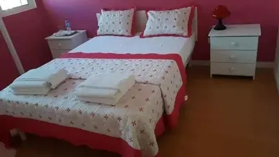 a red bedroom with a bed with towels on it at Chez Zuzu in Mindelo