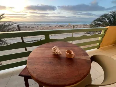 a table on a balcony with a view of the beach at Extraordinary sea view in Sal Rei