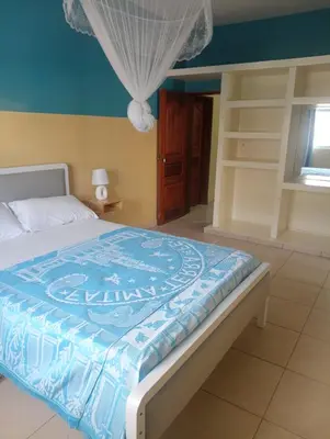a bedroom with a bed with a blue comforter at ANGÉLICA RÉSIDENCE Centre-ville 350 m plage in Tarrafal