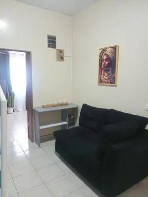 a living room with a black couch and a table at ANGÉLICA RÉSIDENCE Centre-ville 350 m plage in Tarrafal