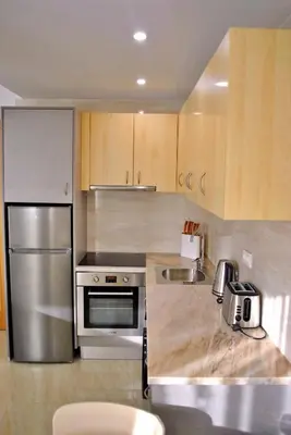 a kitchen with stainless steel appliances and wooden cabinets at Brisa Suites in Santa Maria