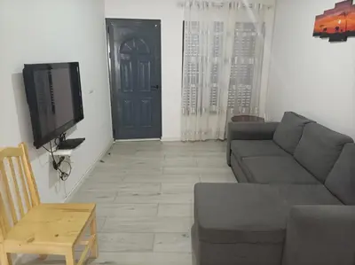 a living room with a couch and a tv and a door at LBranco in Porto Novo
