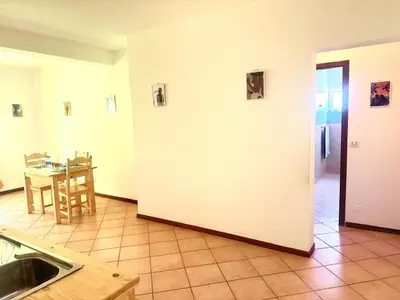 a kitchen and dining room with a table and a white wall at near the beach On bedroom flat very good in Santa Maria