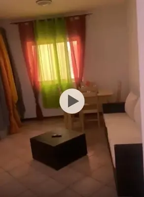 a living room with colorful curtains and a table at near the beach On bedroom flat very good in Santa Maria