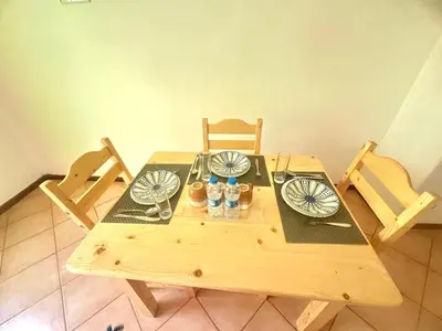 a wooden table with chairs and plates on it at near the beach On bedroom flat very good in Santa Maria