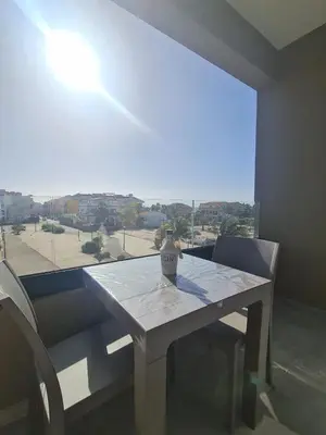 a table and chairs in a room with a large window at Praça do Presidente com vista para o mar in Santa Maria