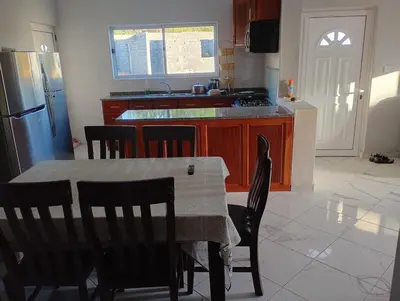 a kitchen with a table and chairs and a refrigerator at Ocean view country house in São Filipe