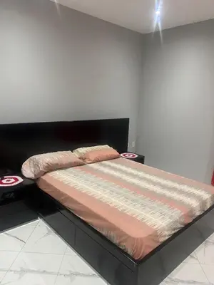 a bed sitting in a room with two tables at Ocean view country house in São Filipe