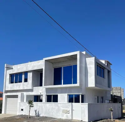 a white house with blue windows at Brand New 2-Bedroom Apartment with AC & Fast Wi-Fi in São Filipe