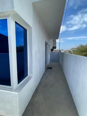 a balcony of a white building with a window at Brand New 2-Bedroom Apartment with AC & Fast Wi-Fi in São Filipe