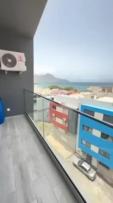 a room with a balcony with a view of the ocean at Appartement Vue Mer in Mindelo