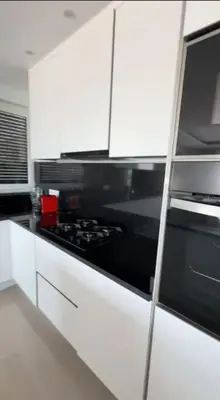 a kitchen with a black stove and white cabinets at Appartement Vue Mer in Mindelo
