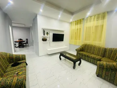 a living room with two couches and a tv at Apartamento T2 mobiliado in Mindelo