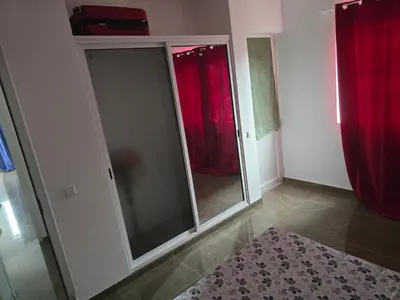a room with glass doors and red curtains at Apartamento Inteiro Porto Novo Abufador in Porto Novo