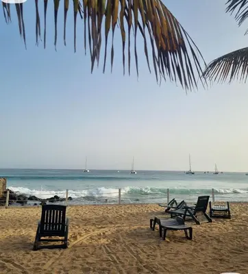 a group of chairs on a beach with the ocean at Comfortable 1-bedroom 400 meters from the beach with Fast Wi-Fi in Santa Maria