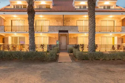 a building with two palm trees in front of it at Villa ao Mar in Santa Maria