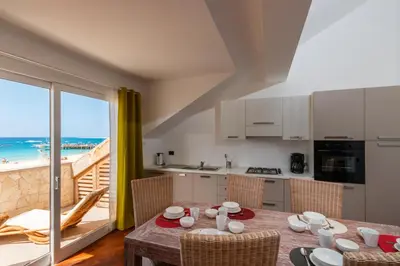 a kitchen and dining room with a table with a view of the beach at Villa ao Mar in Santa Maria