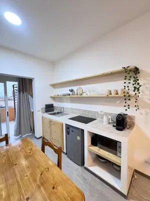 a kitchen with a counter and a table in a room at Bounty Apartment Santa Maria by RPG Group in Santa Maria