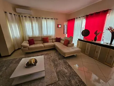 a living room with a couch and red curtains at Casa América in Praia