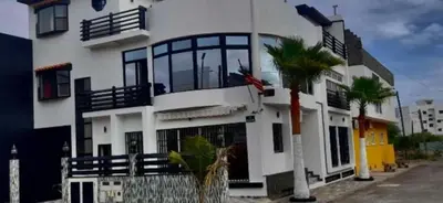 a white building with a palm tree in front of it at Casa América in Praia