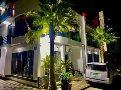 a car parked in front of a building with palm trees at Casa América in Praia