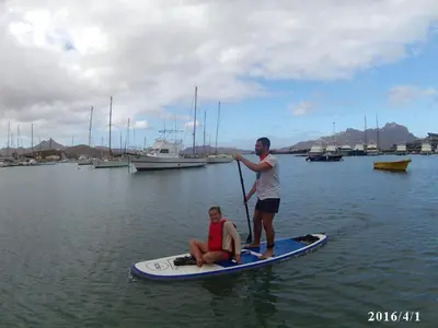 a man and a woman on a paddle board in the water at Arla Residential in Mindelo