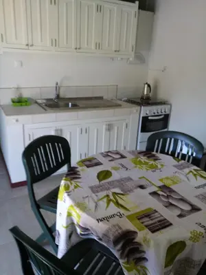 a kitchen with a table and two chairs with a tablecloth at Coin de Paradis,Pavillon Doucimar in Porto Novo